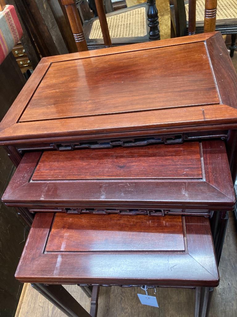 A nest of three Chinese rectangular hardwood tea tables, width 52cm, depth 36cm, height 68cm